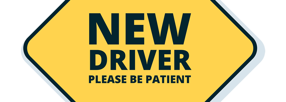 yellow sign that reads new driver, be patient
